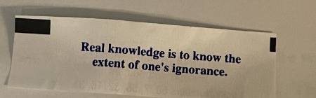 A fortune cookie slip that reads: Real knowledge is to know the extent of one’s ignorance.